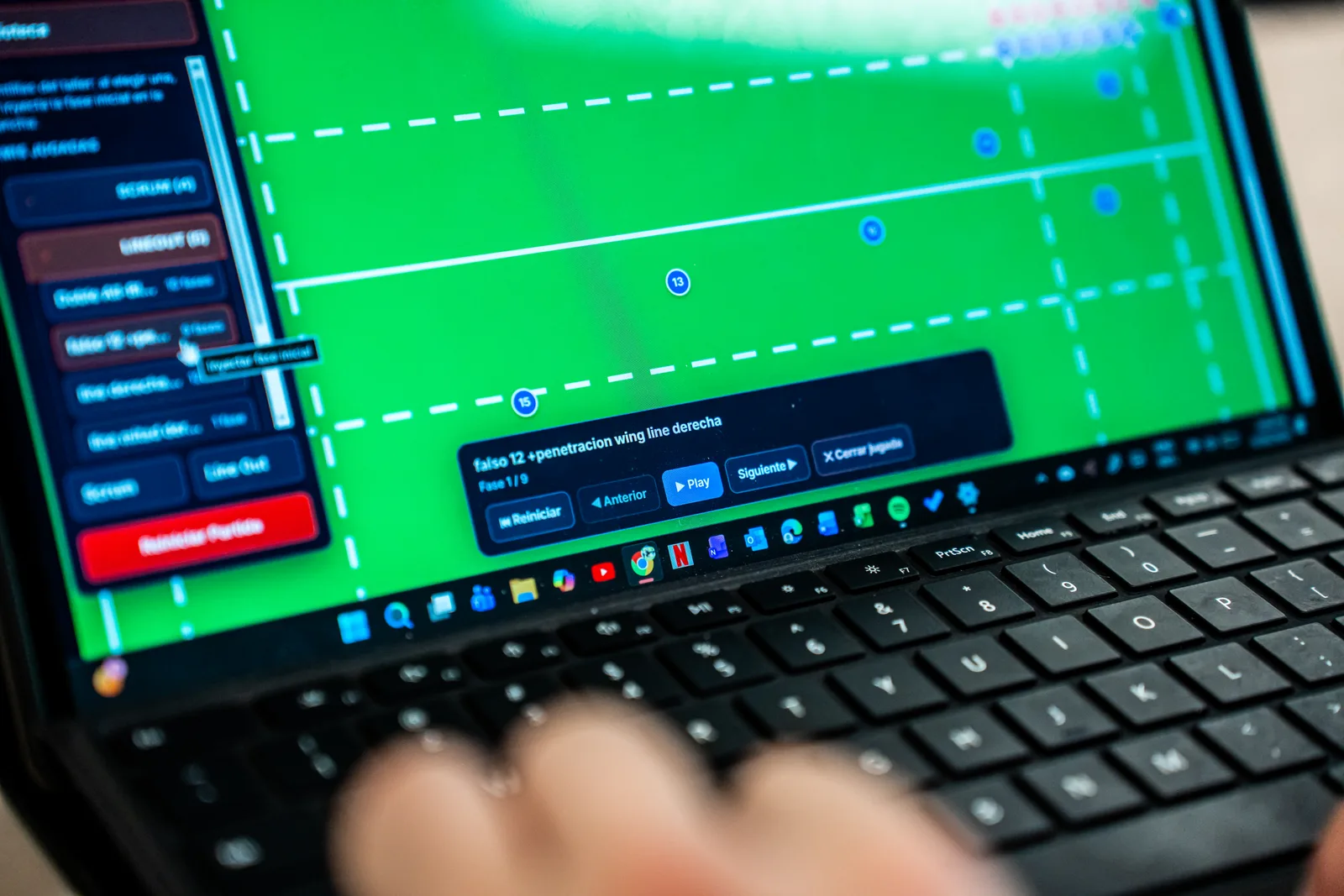 Coach reviewing the playbook on a laptop before training